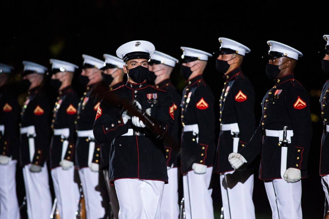 Corporal Xavier Cockrell, number one rifle inspector, Silent Drill Platoon, conducts a rifle inspection during the Friday Evening Parade at Marine Barracks Washington, June 4, 2021. The guest of honor for the evening was The Honorable Michèle A. Flournoy, 9th Undersecretary of Defense for Policy, and the hosting official for the evening was Lt. Gen. Charles G. Chiarotti, Deputy Commandant for Installations and Logistics. (U.S. Marine Corps photo by Lance Cpl. Mark A. Morales)