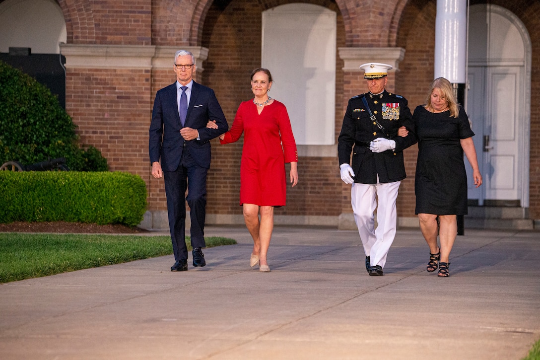 The Honorable Michèle A. Flournoy, 9th Undersecretary of Defense for Policy, and her husband, and Lt. Gen. Charles G. Chiarotti, Deputy Commandant for Installations and Logistics, and his wife, walk down Center Walk during the Friday Evening Parade at Marine Barracks Washington, June 4, 2021.