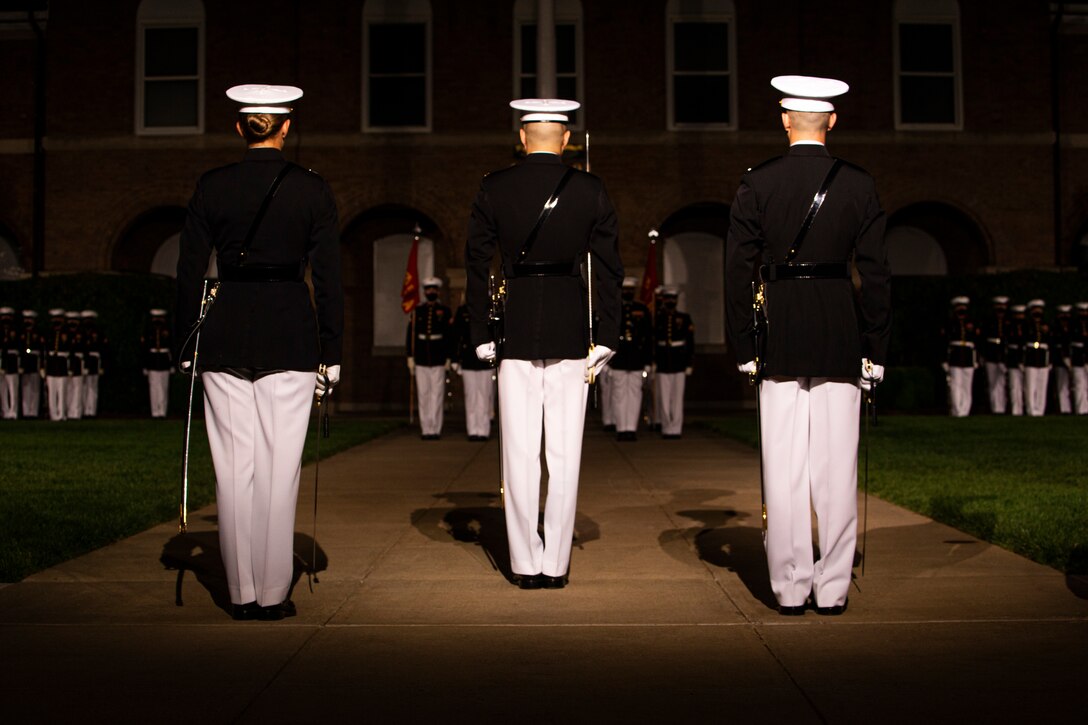 Marines with the parade staff stand at the position of attention during the Friday Evening Parade at Marine Barracks Washington, June 4, 2021. The guest of honor for the evening was The Honorable Michèle A. Flournoy, 9th Undersecretary of Defense for Policy, and the hosting official for the evening was Lt. Gen. Charles G. Chiarotti, Deputy Commandant for Installations and Logistics. (U.S. Marine Corps photo by Lance Cpl. Tanner D. Lambert)