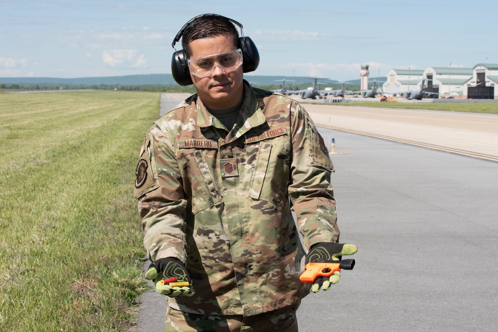 U.S. Air Force Master Sgt. Jose Marrero, noncommissioned officer in charge of airfield management with the 167th Operations Support Group, displays a pyrotechnical device with cartridges used as part of the Bird/wildlife Aircraft Strike Hazards (BASH) program, at the 167th Airlift Wing, Martinsburg, West Virginia, May 12, 2021. The airfield management team uses many noise-making devices to encourage animals to move away from the airfield.