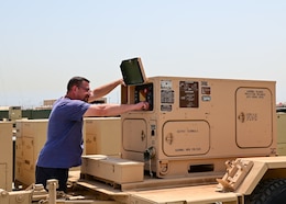 Mitchell D. Holt, a sensor logistics assistance representative at the Regional Support Center, Camp Arifjan, Kuwait, turns on a 10kw AMMPS generators on May 20.  Technicians at the 401st Army Field Support Brigade Communications-Electronics Command RSC recently attained the ability to rebuild 10kw AMMPS generators within the U.S. Central Command. The ability to rebuild generators locally is expected to save money while providing sustainable assists to Soldiers in the field.
