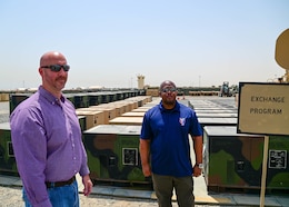 David A. Armstrong, the Communications-Electronics Command senior command representative, and John M. Flaherty, the Regional Support Center manager, stand in front of stock generators belonging to the Theater Provided Equipment One for One Exchange program, at Camp Arifjan, Kuwait, May 20. Armstrong and Flaherty successfully lead the development of the Camp Arifjan RSC 10Kw AMMPS generator rebuild, and TPE One for One Exchange programs.
