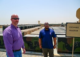 David A. Armstrong, the Communications-Electronics Command senior command representative, and John M. Flaherty, the Regional Support Center manager, stand in front of stock generators belonging to the Theater Provided Equipment One for One Exchange program, at Camp Arifjan, Kuwait, May 20. Armstrong and Flaherty successfully lead the development of the Camp Arifjan RSC 10Kw AMMPS generator rebuild, and TPE One for One Exchange programs.