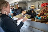 Crystal Cains, the economic opportunity director with the Anchorage Downtown Partnership Ltd, is served food during a culinary demonstration by Alaska Army National Guard culinary specialists. The demonstration was held on Joint Base Elmendorf-Richardson, May 14, to introduce employers to the Alaska Army National Guard’s new Partnership for Youth Success program. The PaYS program is a strategic partnership between the Army National Guard and a cross section of private businesses, universities, and public institutions. It provides Alaska’s newest Citizen-Soldiers the opportunity to increase their prospects for potential civilian employment while serving their country. (U.S. Army National Guard photo by Edward Eagerton)