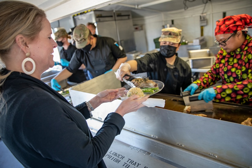 Crystal Cains, the economic opportunity director with the Anchorage Downtown Partnership Ltd, is served food during a culinary demonstration by Alaska Army National Guard culinary specialists. The demonstration was held on Joint Base Elmendorf-Richardson, May 14, to introduce employers to the Alaska Army National Guard’s new Partnership for Youth Success program. The PaYS program is a strategic partnership between the Army National Guard and a cross section of private businesses, universities, and public institutions. It provides Alaska’s newest Citizen-Soldiers the opportunity to increase their prospects for potential civilian employment while serving their country. (U.S. Army National Guard photo by Edward Eagerton)