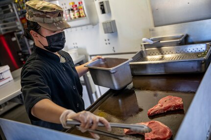 Sgt. Patricia Catacutan prepares food during a culinary demonstration by Alaska Army National Guard culinary specialists on Joint Base Elmendorf-Richardson, May 14, as part of the Alaska Army National Guard’s new Partnership for Youth Success program. The PaYS program is a strategic partnership between the Army National Guard and a cross section of private businesses, universities, and public institutions. It provides Alaska’s newest Citizen-Soldiers the opportunity to increase their prospects for potential civilian employment while serving their country. (U.S. Army National Guard photo by Edward Eagerton)