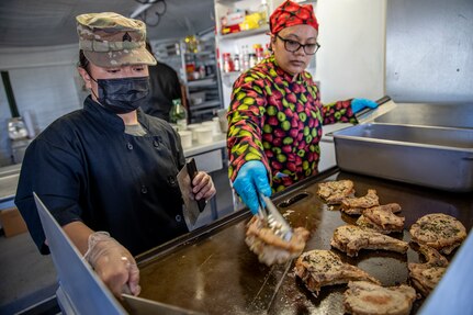 Sgt. Patricia Catacutan and Master Sgt. Lala Kauahi prepare food during a culinary demonstration by Alaska Army National Guard culinary specialists on Joint Base Elmendorf-Richardson, May 14, as part of the Alaska Army National Guard’s new Partnership for Youth Success program. The PaYS program is a strategic partnership between the Army National Guard and a cross section of private businesses, universities, and public institutions. It provides Alaska’s newest Citizen-Soldiers the opportunity to increase their prospects for potential civilian employment while serving their country. (U.S. Army National Guard photo by Edward Eagerton)