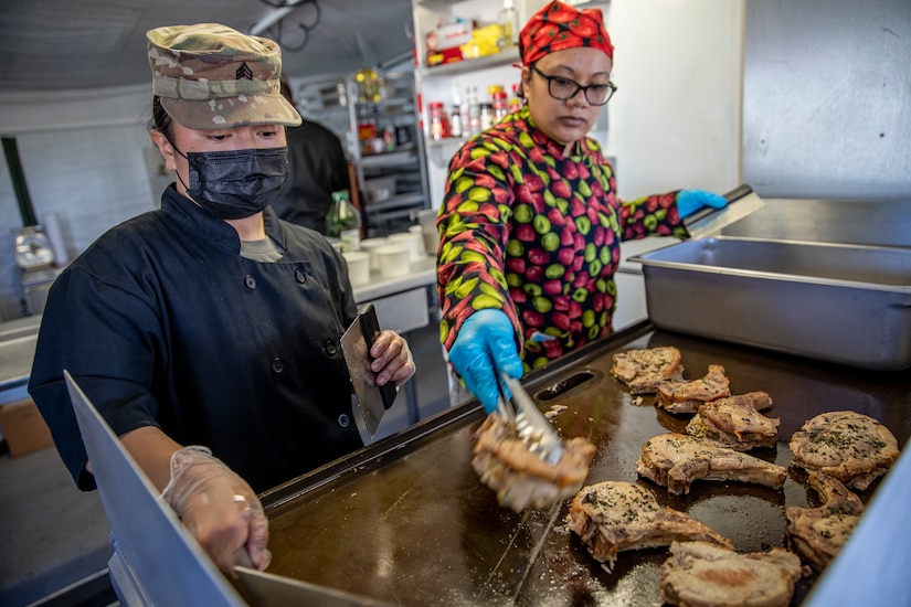 Sgt. Patricia Catacutan and Master Sgt. Lala Kauahi prepare food during a culinary demonstration by Alaska Army National Guard culinary specialists on Joint Base Elmendorf-Richardson, May 14, as part of the Alaska Army National Guard’s new Partnership for Youth Success program. The PaYS program is a strategic partnership between the Army National Guard and a cross section of private businesses, universities, and public institutions. It provides Alaska’s newest Citizen-Soldiers the opportunity to increase their prospects for potential civilian employment while serving their country. (U.S. Army National Guard photo by Edward Eagerton)