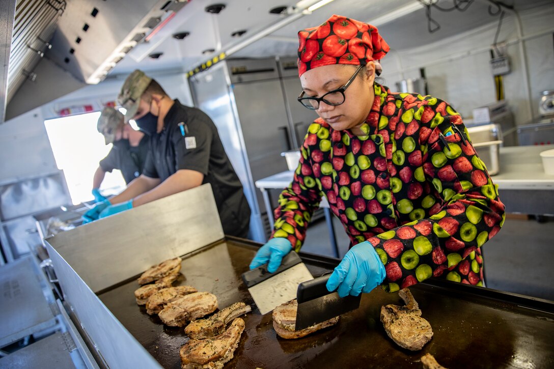 Master Sgt. Lala Kauahi prepares food during a culinary demonstration by Alaska Army National Guard culinary specialists on Joint Base Elmendorf-Richardson, May 14, as part of the Alaska Army National Guard’s new Partnership for Youth Success program. The PaYS program is a strategic partnership between the Army National Guard and a cross section of private businesses, universities, and public institutions. It provides Alaska’s newest Citizen-Soldiers the opportunity to increase their prospects for potential civilian employment while serving their country. (U.S. Army National Guard photo by Edward Eagerton)