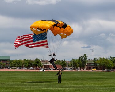 a man with a parachute lands on a field.