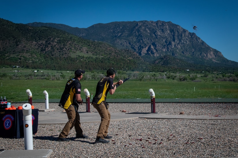 two men shoot at clay targets.