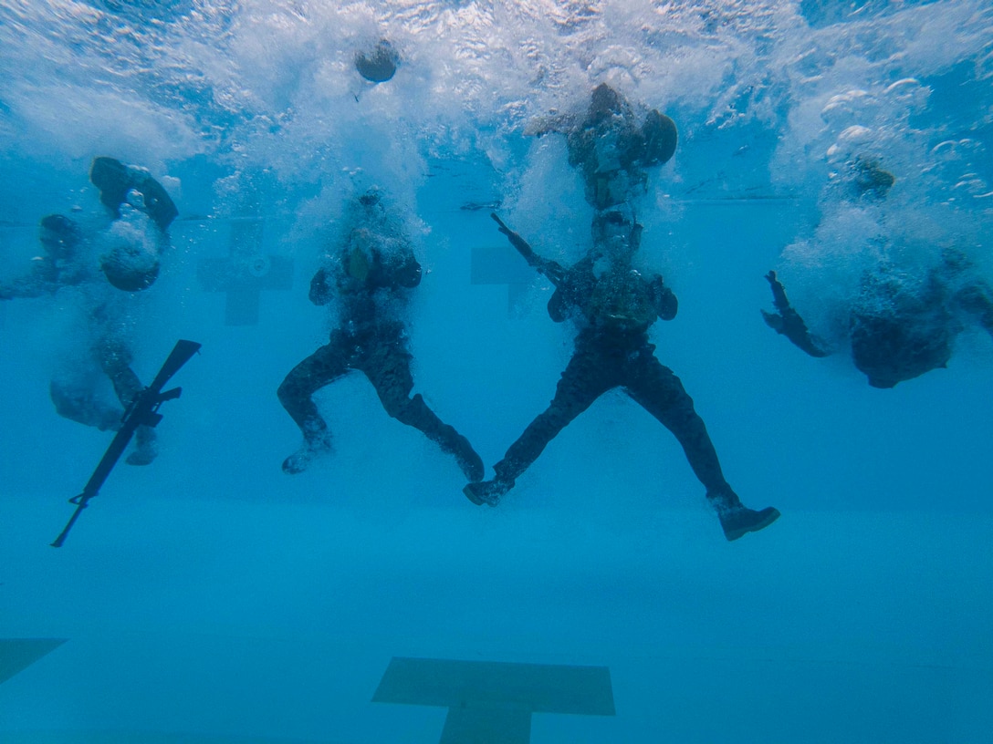 U.S. Marines conduct an underwater gear shed during the Water Survival Basic (WSB) course on Camp Foster, Okinawa, Japan, May 28, 2021. Every Marine is required to complete the WSB swim qualification every two years and have a follow-on opportunity to attempt the advanced Water Survival Intermediate course. (U.S. Marine Corps photo by Lance Cpl. Alex Fairchild)