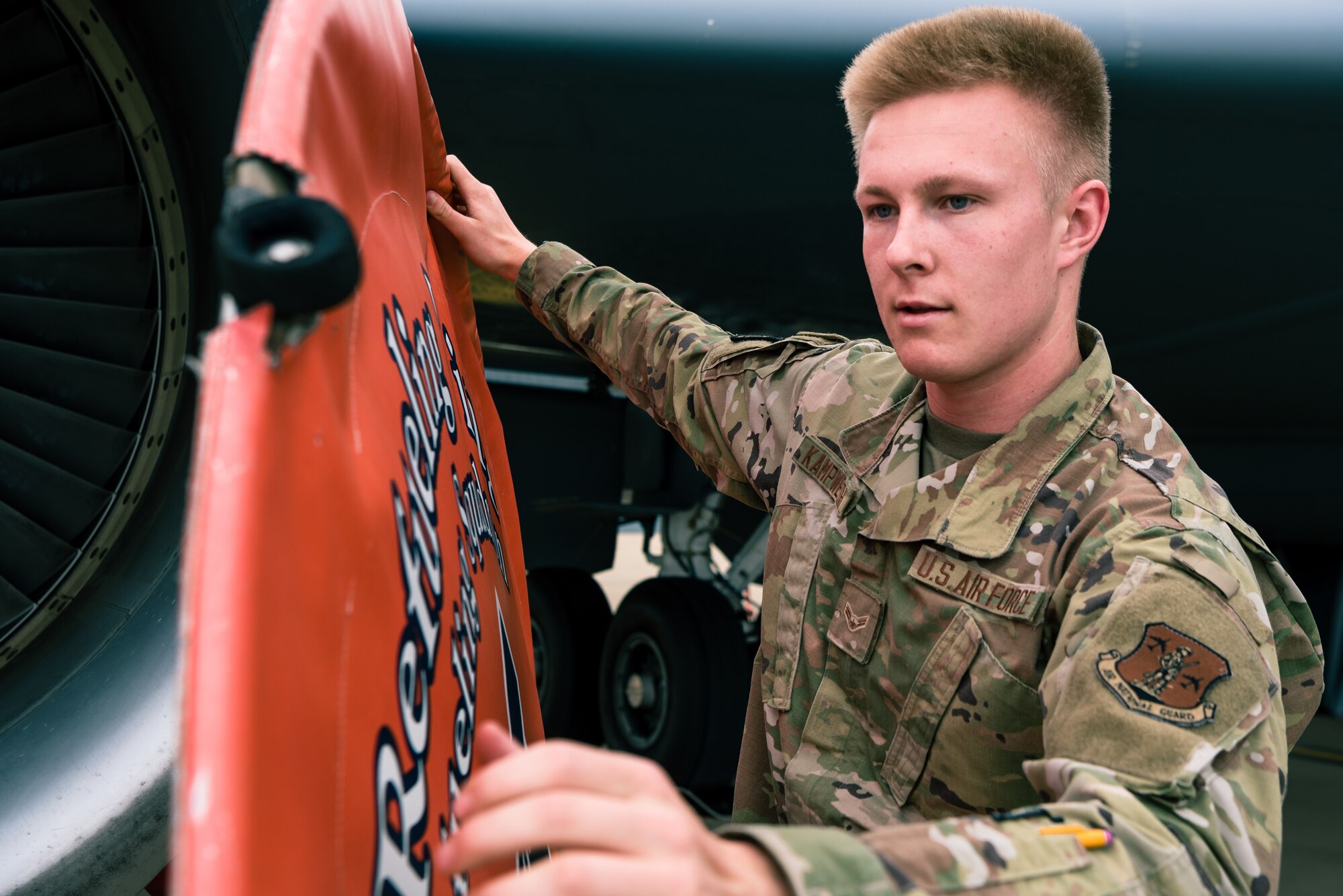 U.S. Air National Guard Airman 1st Class Paul Kampwerth, 126th Air Refueling Squadron hydraulics apprentice, equips an engine cover on a KC-135 Stratotanker on Scott Air Force Base, Illinois, June 2, 2021. Kampwerth was putting on the engine cover to prevent debris from interfering with the aircraft engines while routine maintenance was performed. (U.S. Air Force photo by Airman 1st Class Mark Sulaica)