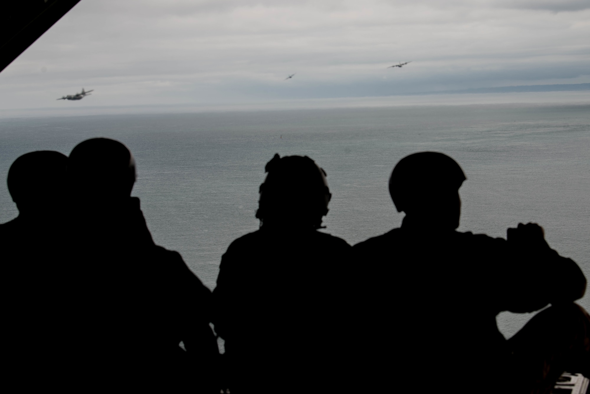 Airmen sit on edge of plane