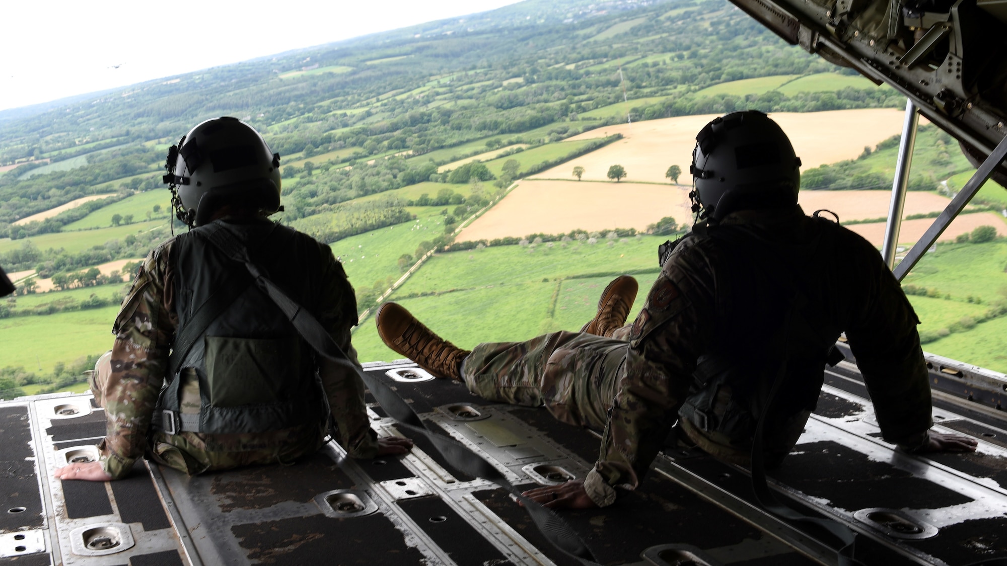 Airmen look out the back of a C-130J