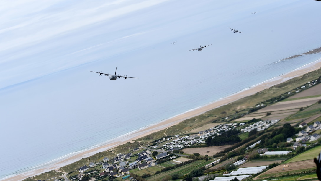Aircraft fly in formation above Normandy, France.