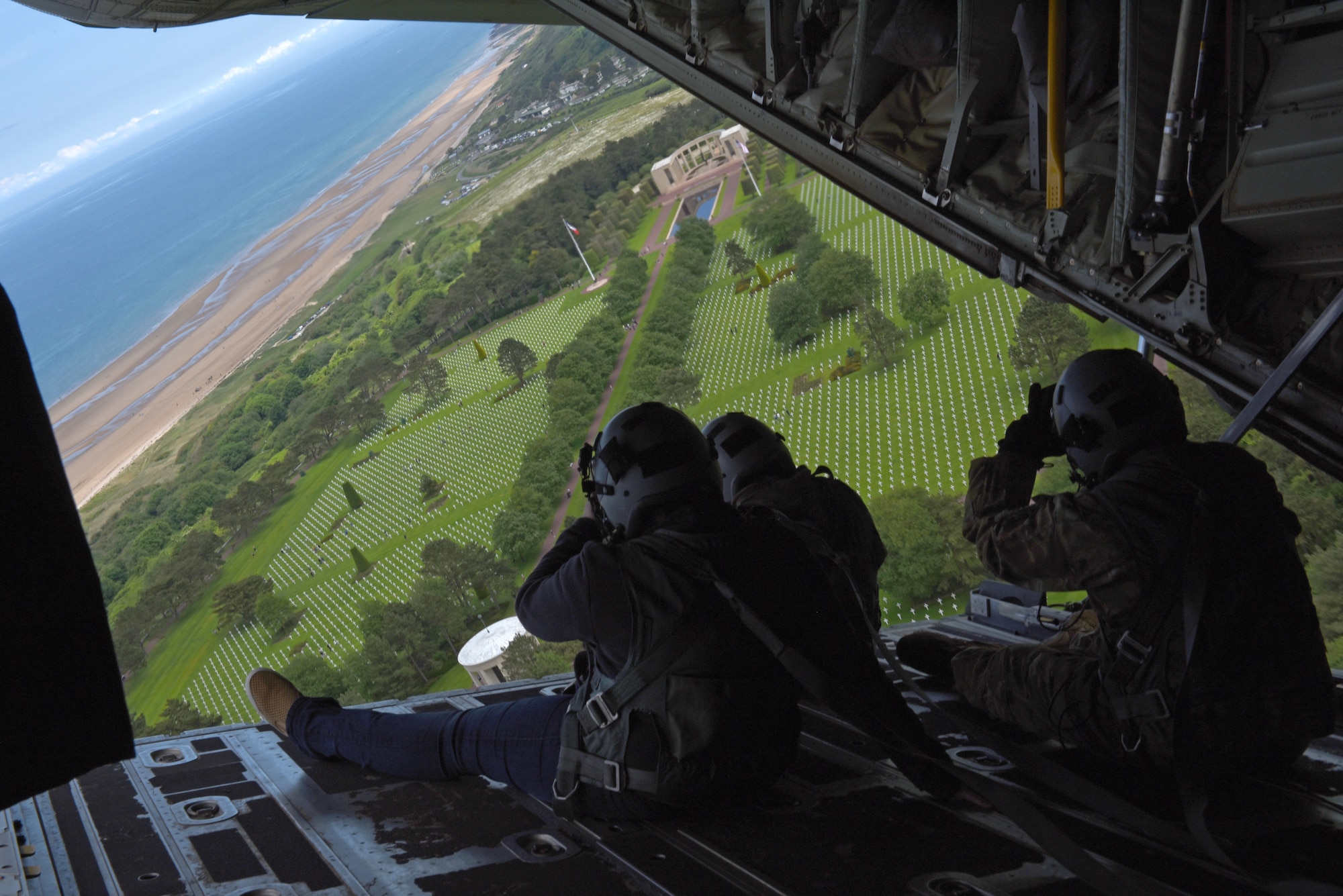 Airmen look out the back of a C-130J