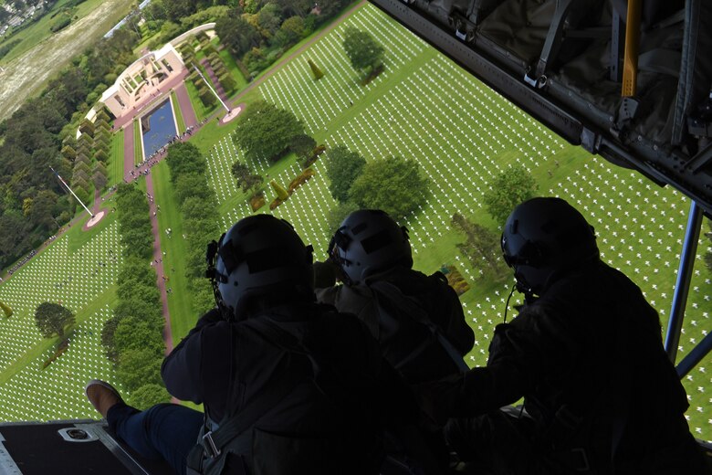 Airmen look out the back of a C-130J