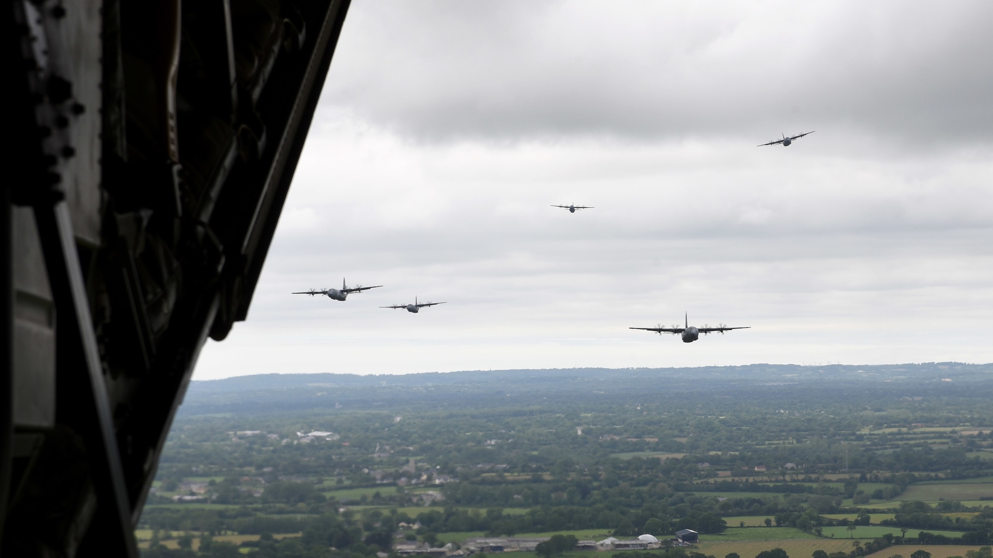 Aircraft fly in formation above Normandy, France.