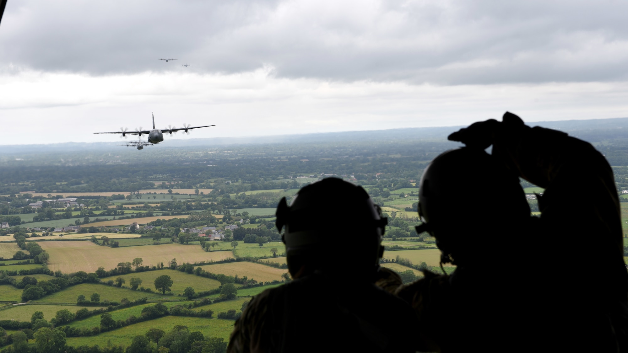 Airmen look out the back of a C-130J