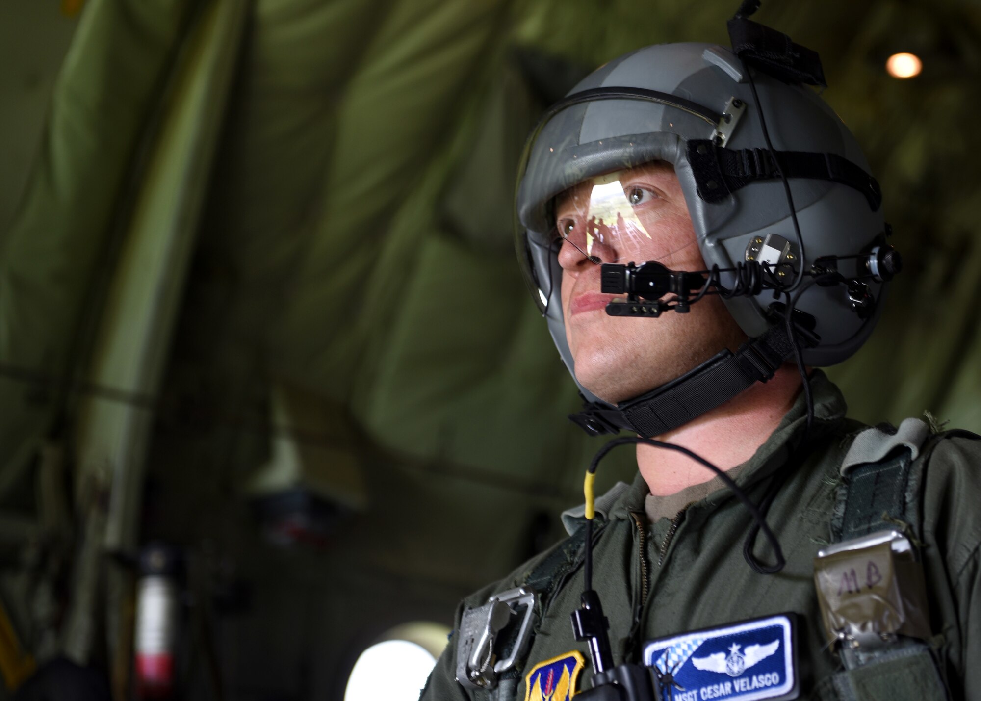 Airmen look out the back of a C-130J