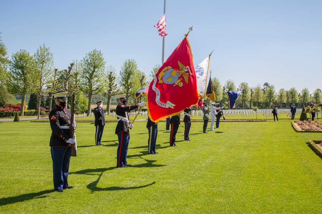 A joint color guard participates in a ceremony at Aisne-Marne American Cemetery in Belleau, France, May 30, 2021. The ceremony was held Memorial Day weekend in commemoration of the 103rd anniversary of the battle of Belleau Wood, conducted to honor the legacy of service members who gave their lives in defense of the United States and European allies. U.S. Marines and Sailors from Marine Corps Forces Europe and Africa, 5th Marine Regiment, 6th Marine Regiment, 1st Marine Division band, U.S. Soldiers from the Army 26th Infantry Division, 2nd Infantry Division representatives, German and French service members, and local officials participated in the ceremony. The joint color guard included the U.S. Army colors, a first for the historic ceremony. This was the first time since the battle over a century ago that U.S. Marine Corps, U.S. Army, U.S. Navy, French, and German service members were all present for the ceremonies.  (U.S. Marine Corps photo by Staff Sgt. Brytani Musick)