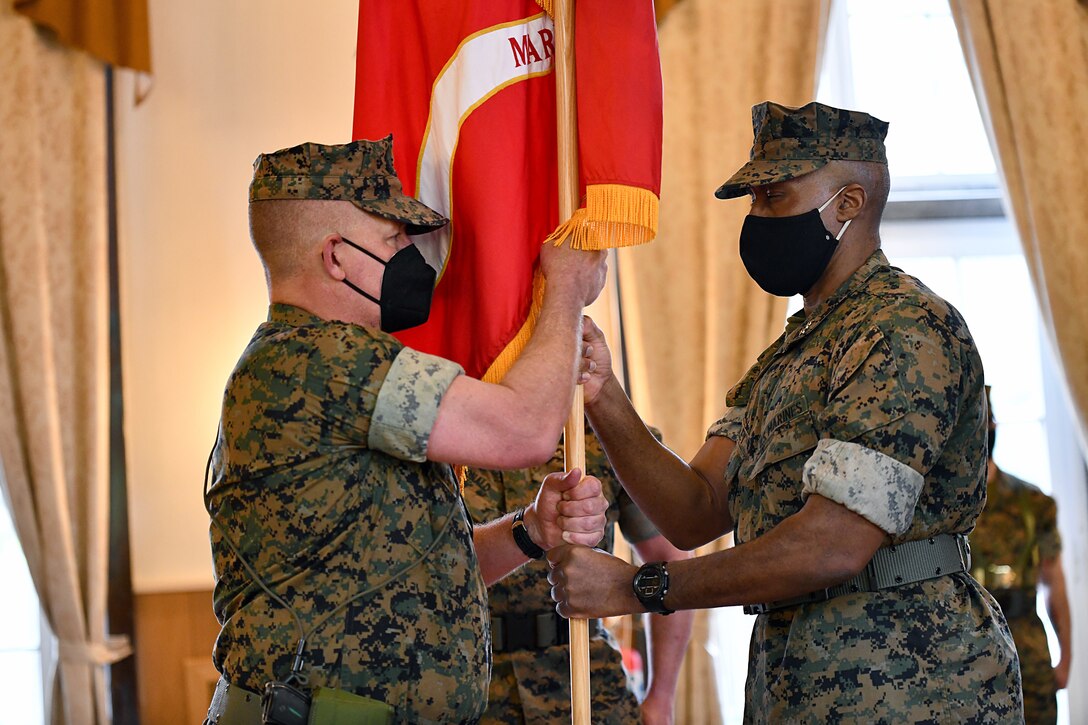 U.S. Marine Corps Maj. Gen. Tracy W. King, left, incoming commander of U.S. Marine Corps Forces, Europe and Africa (MARFOREUR/AF), receives the organizational colors from outgoing commander Maj. Gen. Michael E. Langley, right, during the MARFOREUR/AF change of command ceremony at the U.S. Army Garrison Stuttgart firehouse in Boeblingen, Germany, May 6, 2021. This ceremony recognizes the significance of the passage of command, honors the accomplishments of the organization under the outgoing commander, and formally appoints the incoming commander. This ceremony recognizes the significance of the passage of command, honors the accomplishments of the organization under the outgoing commander, and formally appoints the incoming commander. (U.S. Army Photo by Jason Johnston)