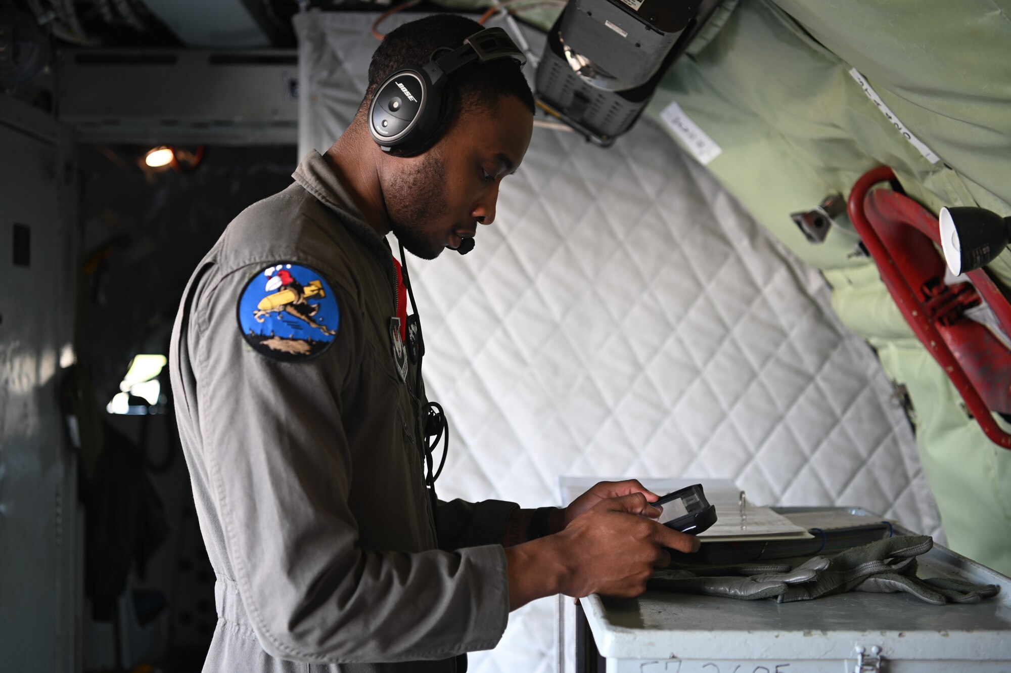 U. S. Air Force Tech. Sgt. Alex Govan, 351st Air Refueling Squadron boom operator, goes over a checklist prior to takeoff at Royal Air Force Mildenhall, England, June 4, 2021. The checklist is apart of a pre-flight inspection to ensure the aircraft was fit to fly over Omaha Beach, France, for a ceremony in honor of Charles Norman Shay, who served in the first wave attack on the beach. (U.S. Air Force photo by Staff Sgt. Matthew J. Wisher)