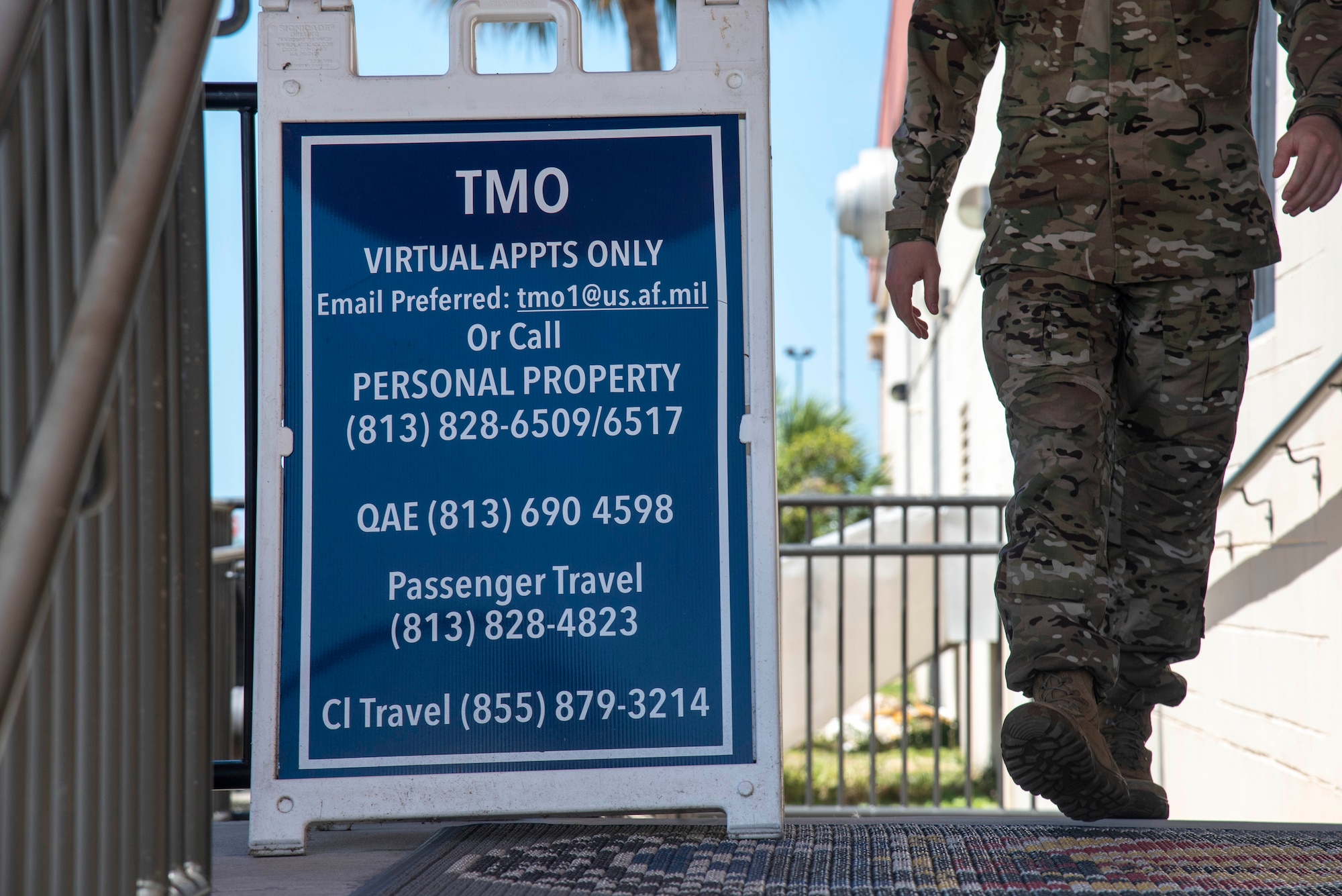 A U.S. Air Force Airman walks past a sign at the 6th Logistics Readiness Squadron Traffic Management Office (TMO) entrance at MacDill Air Force Base, Florida, May 26, 2021. Any military member who is retiring, separating or changing duty stations will work with TMO, specifically personal property and passenger travel, to get their personal belongings shipped to their next home.