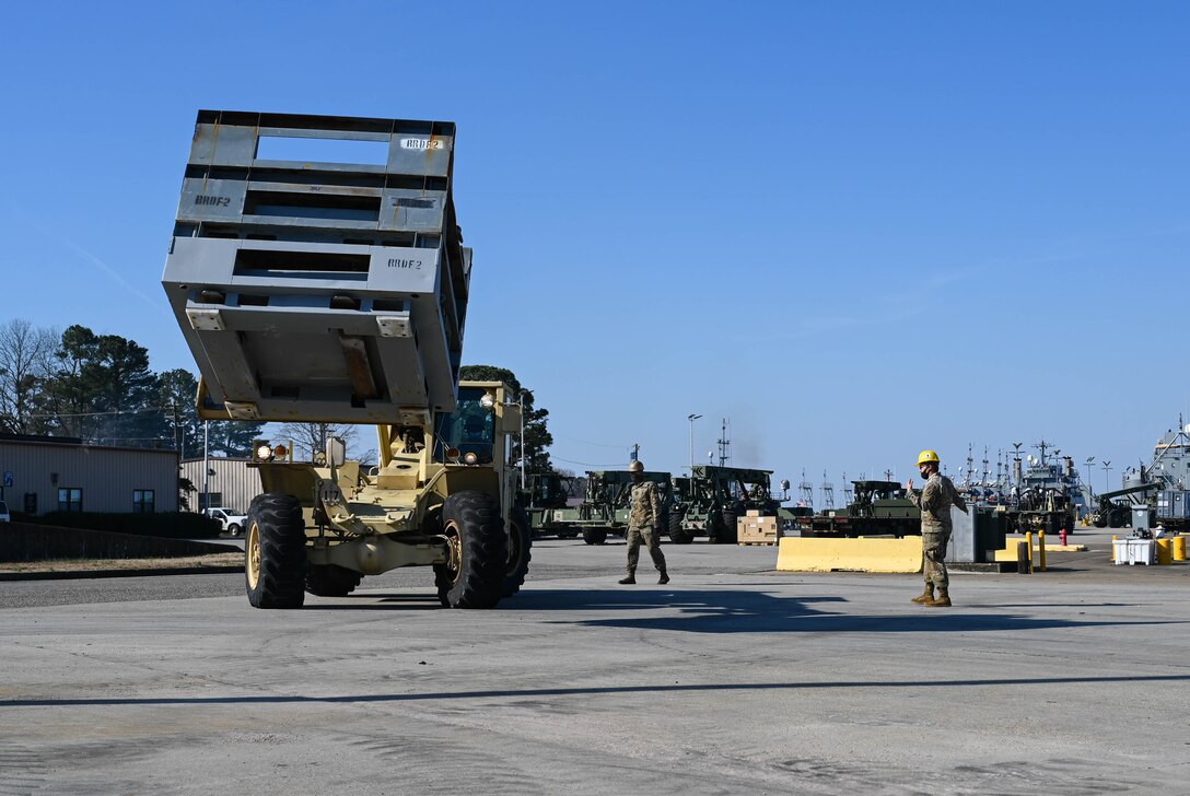 U.S. Soldiers from the 7th Transportation Brigade (Expeditionary) operate machinery at 3rd Port, Joint Base Langley-Eustis, Virginia, March 9, 2021. The loaded equipment and supplies were transported by barge to Naval Station Norfolk. (U.S. Air Force photo by Senior Airman Sarah Dowe)
