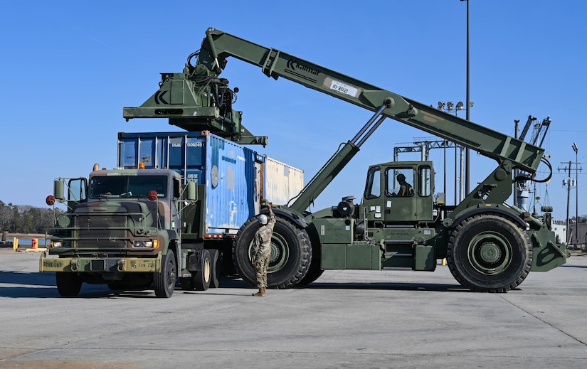 U.S. Soldiers from the 7th Transportation Brigade (Expeditionary) move shipping crates at 3rd Port, Joint Base Langley-Eustis, Virginia, March 9, 2021. The crates were transported by barge to Naval Station Norfolk to be sent on future deployments. (U.S. Air Force photo by Senior Airman Sarah Dowe)