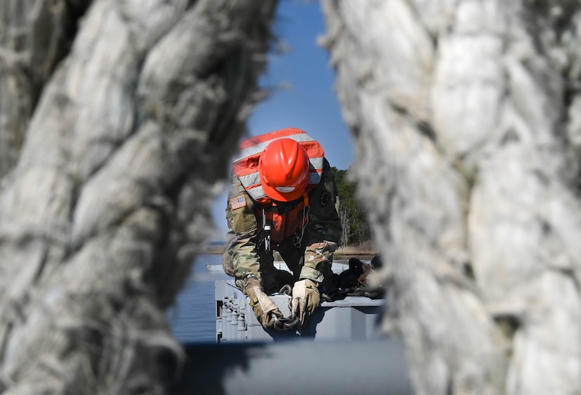 A U.S. Soldier from the 7th Transportation Brigade (Expeditionary) secures a shipping crate aboard a barge at 3rd Port, Joint Base Langley-Eustis, Virginia, March 9, 2021. The supplies and equipment were loaded within a few days time and transported to an exercise. (U.S. Air Force photo by Senior Airman Sarah Dowe)