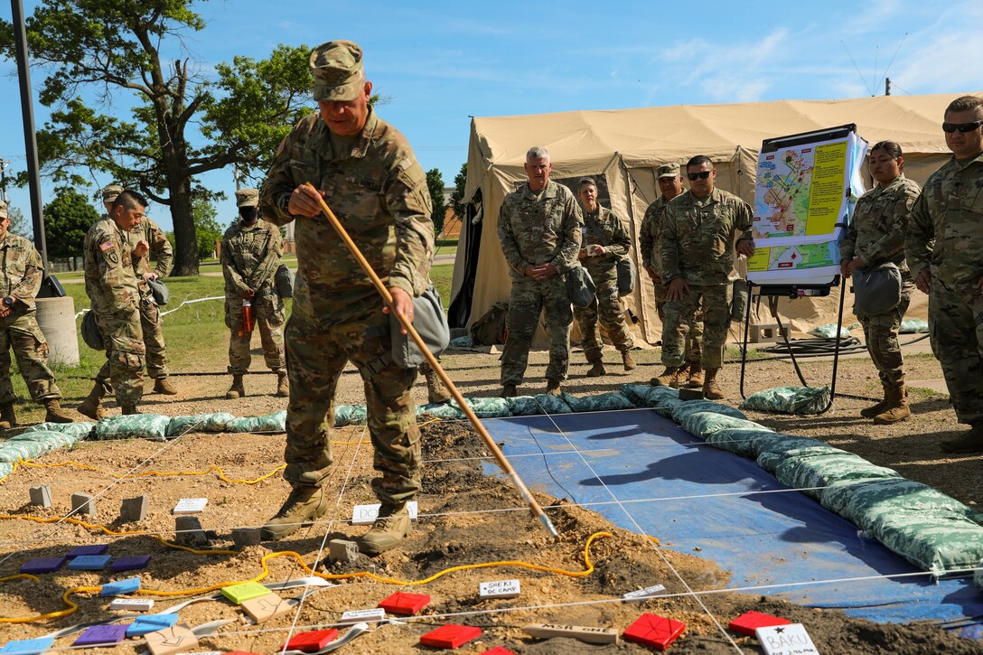 U.S. Army Reserve Maj. Richard Flores, 358th Civil Affairs Brigade points out major units and objectives during the Rehearsal of Concept drill, Command Post Exercise – Functional (CPX-F) 21-02 at Ft. McCoy, Wis., June 5, 2021.  Units from across U.S. Army Civil Affairs and Psychological Operations Command (Airborne) are working together at Ft. McCoy to improve readiness and staff interoperability in support of the U.S. Army Reserve’s mission of a globally responsive force ready to deploy at a moment's notice.