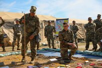 U.S. Army Reserve Maj. Richard Flores, 358th Civil Affairs Brigade, gets an assist from Spec. Kyle Moller, a Civil Affairs Specialist with the 364th Civil Affairs Brigade and augmentee to the exercise S2 section as they brief the change in phases during the rehearsal of concept brief at Command Post Exercise – Functional (CPX-F) 21-02, June 5, 2021, at Ft. McCoy, Wis. CPX-F brings units from across the command together to work in cooperation in an exercise scenario that mirrors real-world mission concerns.