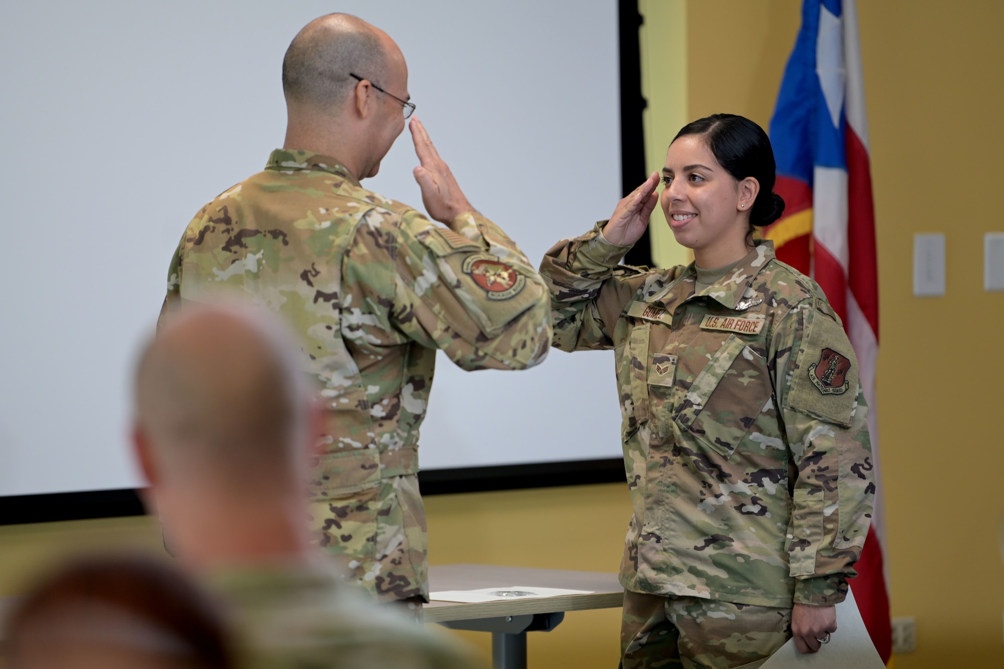 U.S. Senior Airman Amanda Gomez, with the 156th Operations Group, Host Nation Rider Flight, salutes Lt. Col. Raul Nieves, the 156th HNR officer in charge, after receiving his diploma for completing the Basic Airborne Mission Systems Operator course, May 25, 2021 at the 156th Wing, Muñiz Air National Guard Base, Puerto Rico. The nine Airmen that graduated the course are the first qualified Host Nation Rider BAMSOs in the Puerto Rico Air National Guard. (U.S. Air National Guard photo by Master Sgt. Caycee Watson)