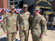 three men in army uniforms pose for a photo.