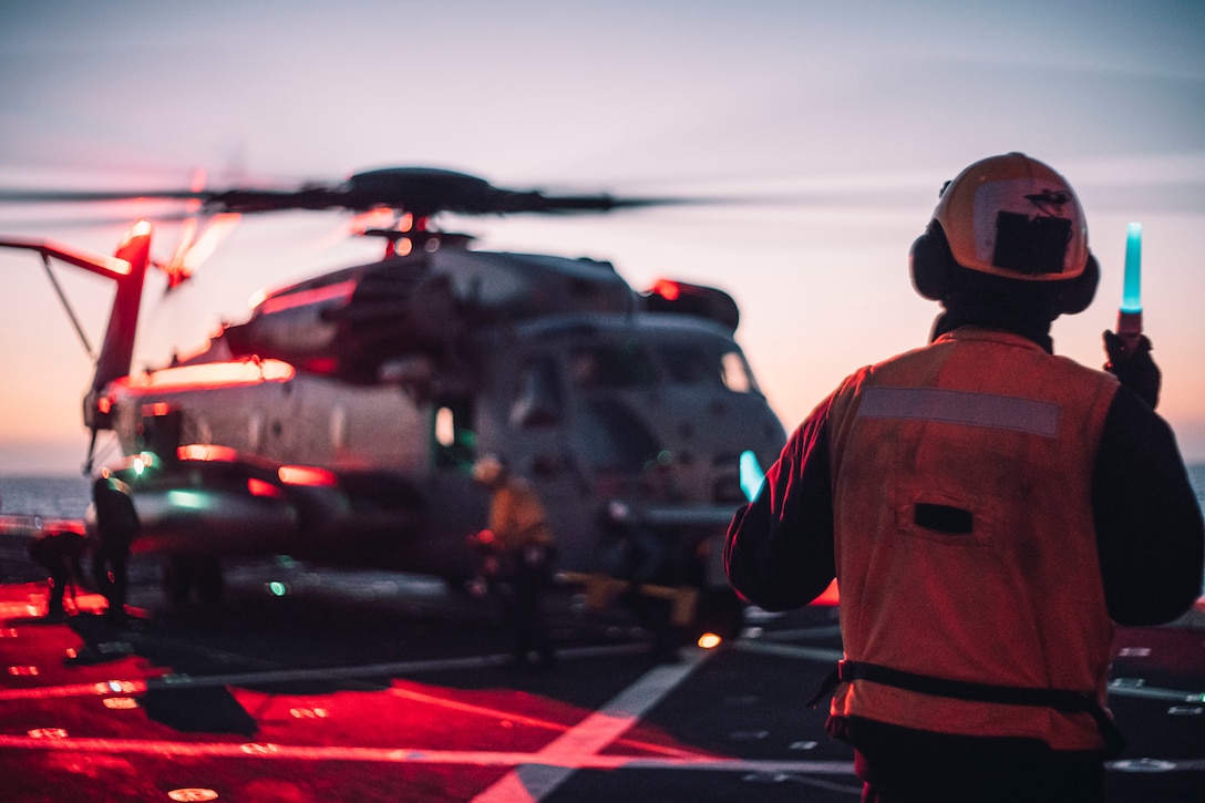 A U.S. Sailor assigned to amphibious transport dock USS Portland signals a CH-53E Super Stallion assigned to Marine Medium Tiltrotor Squadron 65, 11th MEU, on the ship’s flight deck before takeoff, May 18, 2021. Marines and Sailors of the 11th MEU and Essex Amphibious Ready Group are underway conducting integrated training off the coast of southern California.