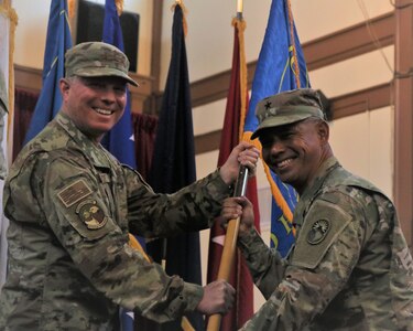 U.S. Army Brig. Gen. Lance A. Okamura and U.S. Navy Rear. Adm. Timothy C. Kuehhas pose for a photo.