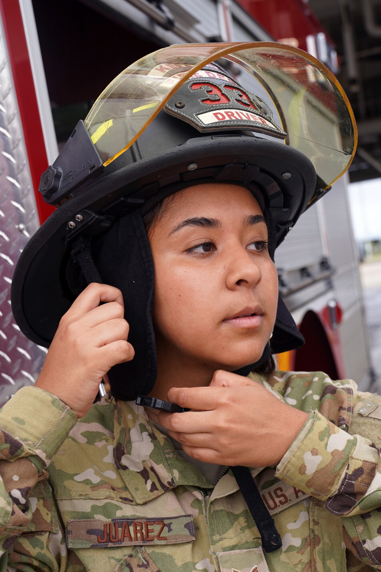 U.S. Air Force Airman 1st Class Cinthia Juarez, 81st Civil Engineer Squadron driver operator, puts on a fire protection helmet outside the fire station at Keesler Air Force Base, Mississippi, June 2, 2021. The Keesler Fire Department responds to medical emergencies on and around base 24 hours a day. (U.S. Air Force photo by Senior Airman Seth Haddix)