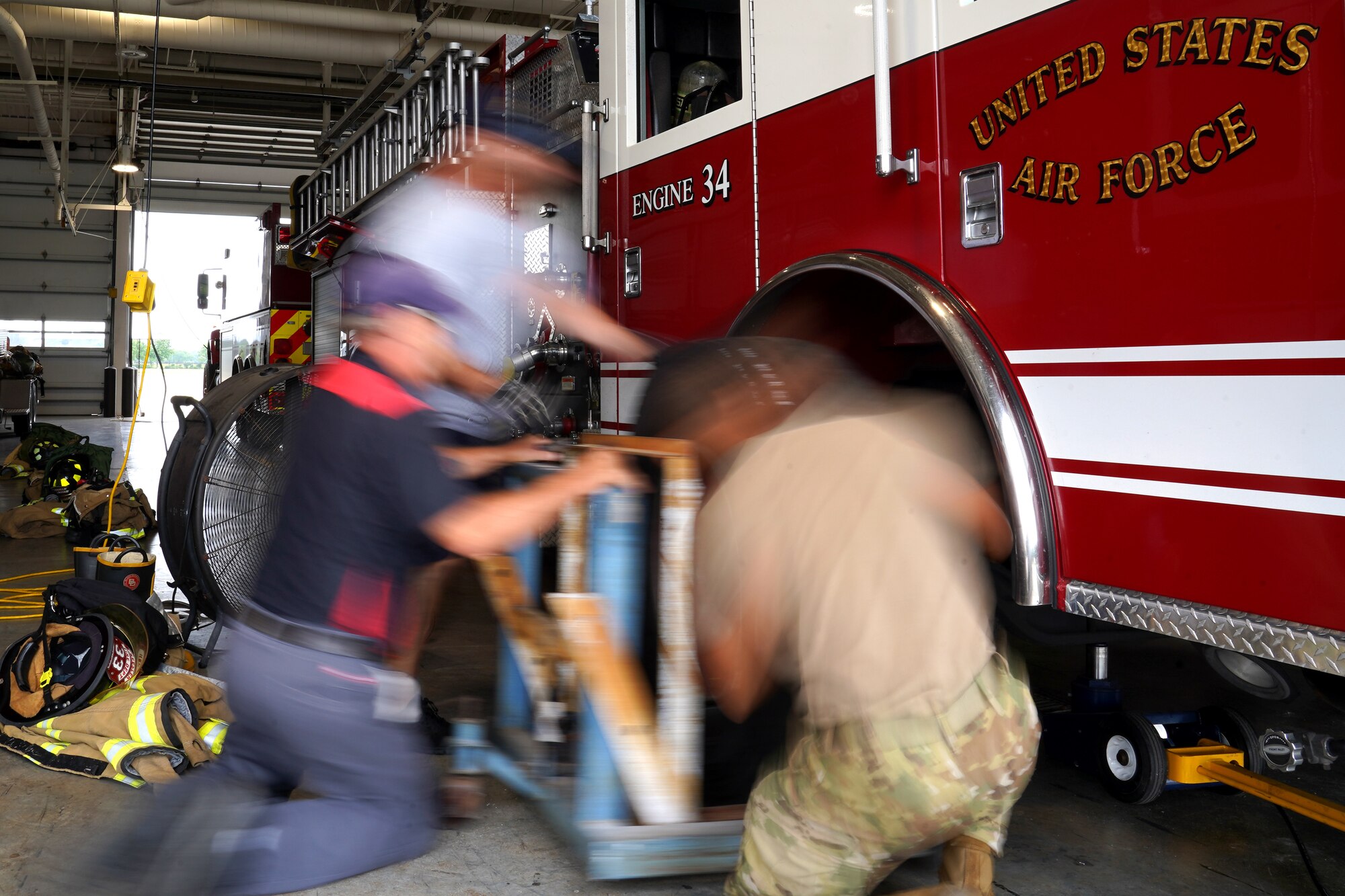 U.S. Air Force Airman 1st Class Kevin Munoz, 81st Civil Engineer Squadron firefighter, Dave Cleland, 81st CES crew chief, and Jerry Krumnow, 81st CES fire truck mechanic, replace a tire on a fire truck at the fire station at Keesler Air Force Base, Mississippi, June 2, 2021. The Keesler Fire Department responds to medical emergencies on and around base 24 hours a day. (U.S. Air Force photo by Senior Airman Seth Haddix)
