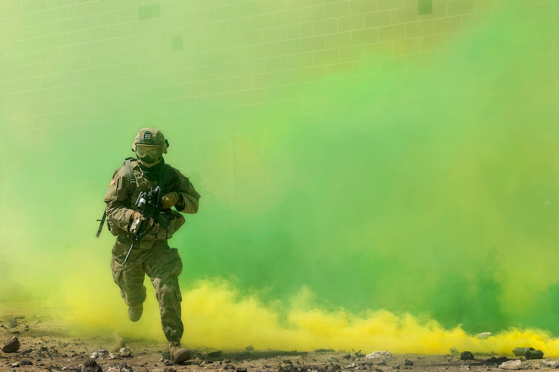 A guardsman runs through green smoke while holding a weapon.