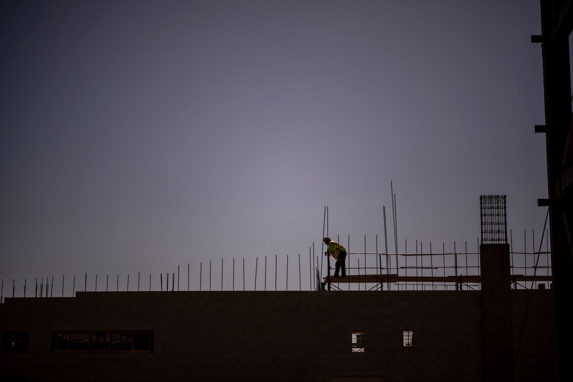 A silhouette of a man on the top of a building.