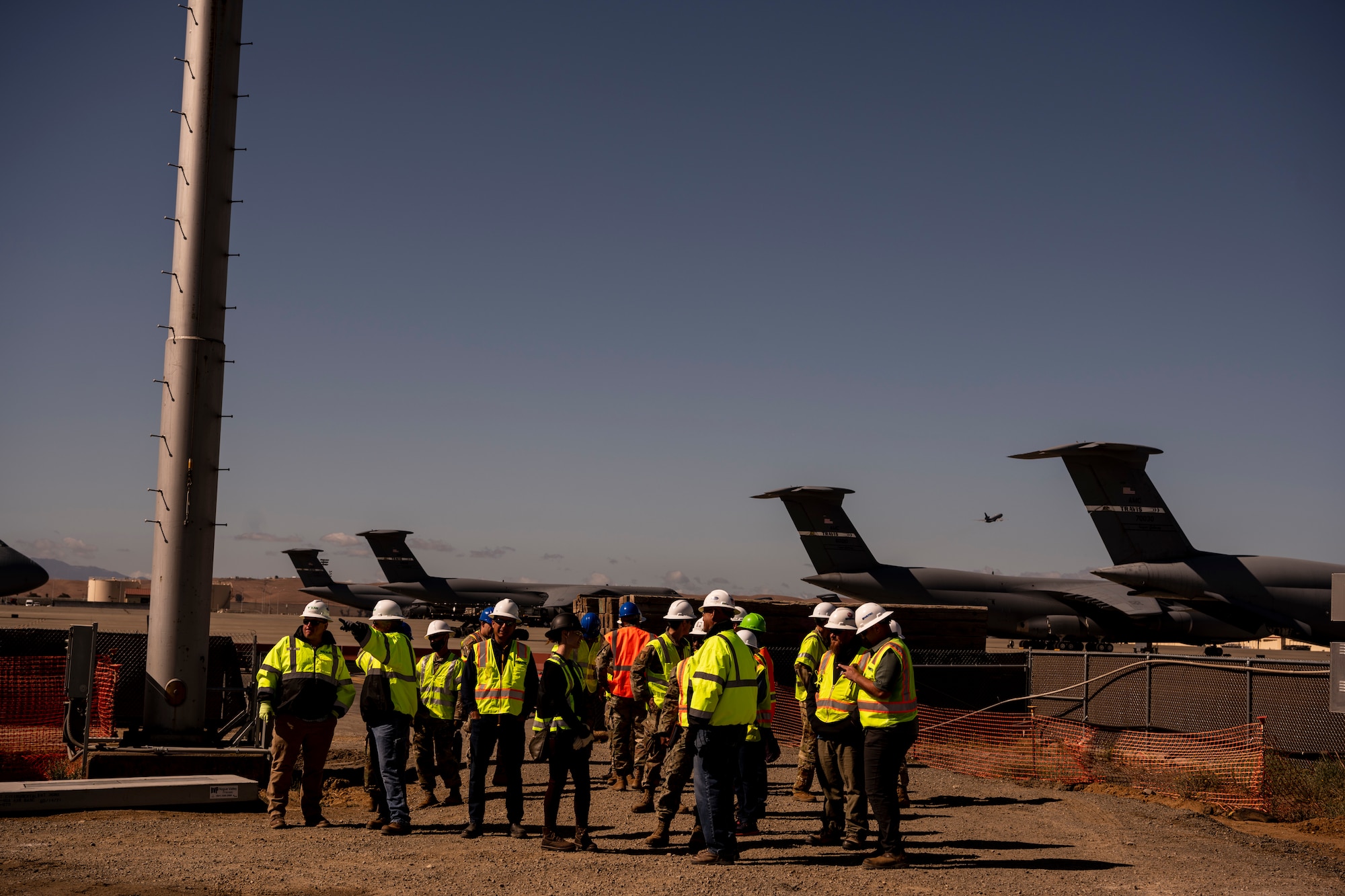 A group of people stand together on a construction site.