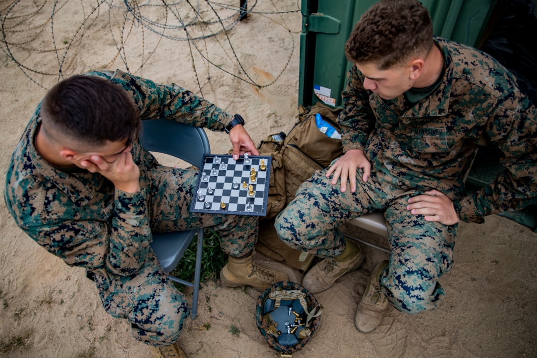 U.S. Marine Corps Lance Cpl. Mark G. Geospatial, and Lance Cpl. Lee Zachary, intelligence analysts with Task Force Koa Moana 21, I Marine Expeditionary Force, increase their critical thinking and problem solving abilities by playing a game of chess while on a break during a communications exercise on Marine Corps Base Camp Pendleton, California, May 13, 2021. This exercise will increase the capabilities and proficiency of the Marines as they prepare for future deployments.