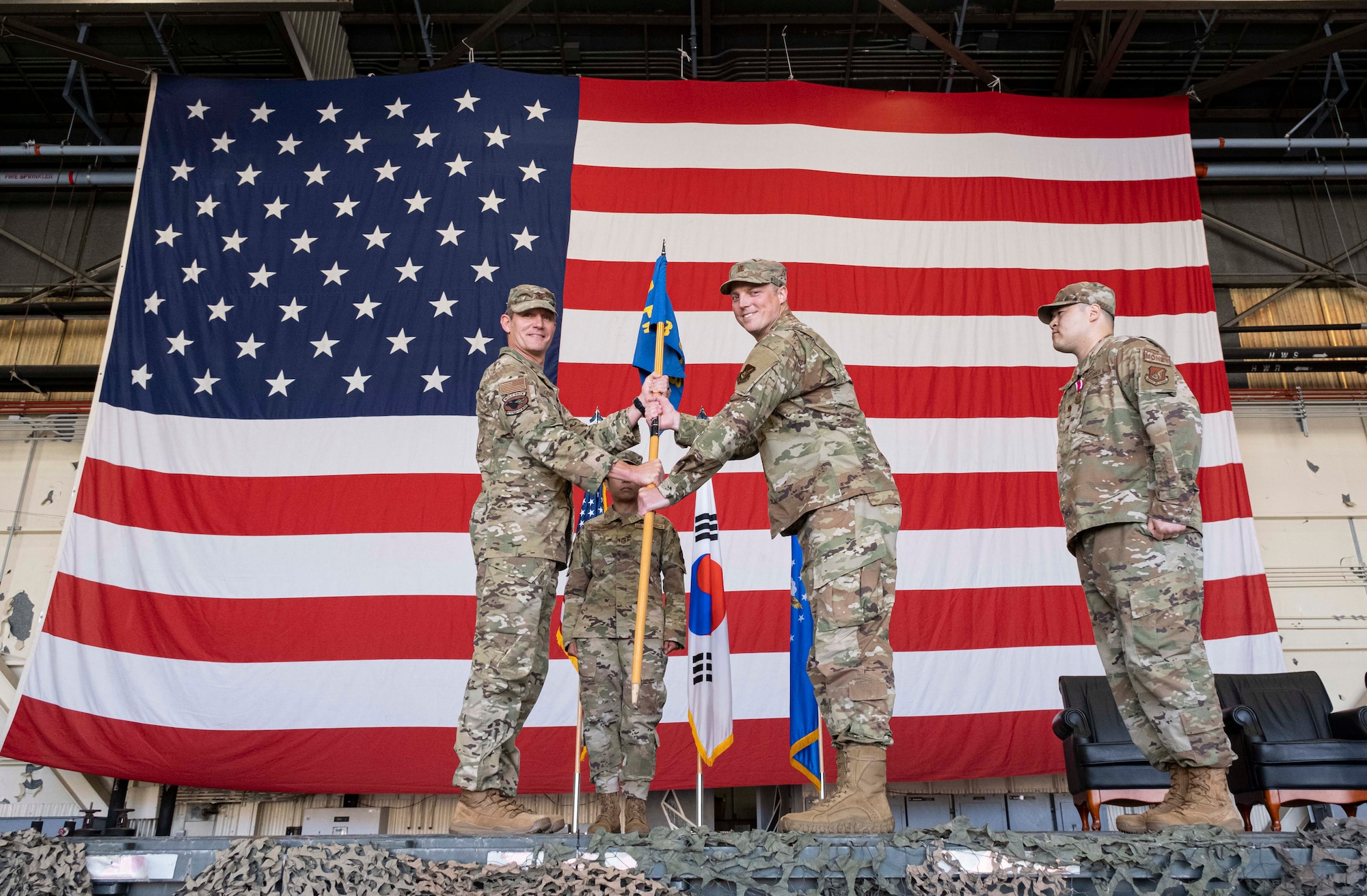 Two commanders pose for a photo during a ceremony.