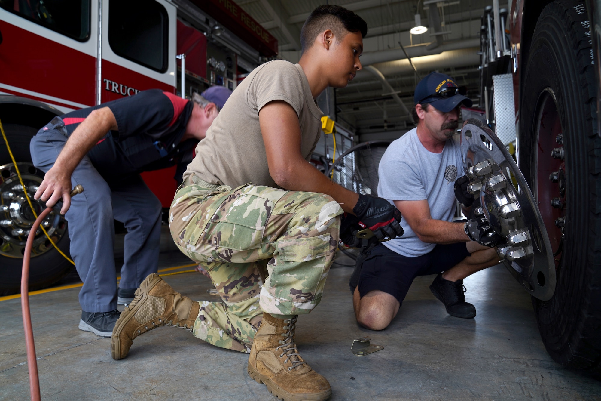 U.S. Air Force Airman 1st Class Kevin Munoz, 81st Civil Engineer Squadron firefighter, Dave Cleland, 81st CES crew chief, and Jerry Krumnow, 81st CES fire truck mechanic, replace a tire on a fire truck at the fire station at Keesler Air Force Base, Mississippi, June 2, 2021. The Keesler Fire Department responds to medical emergencies on and around base 24 hours a day. (U.S. Air Force photo by Senior Airman Seth Haddix)
