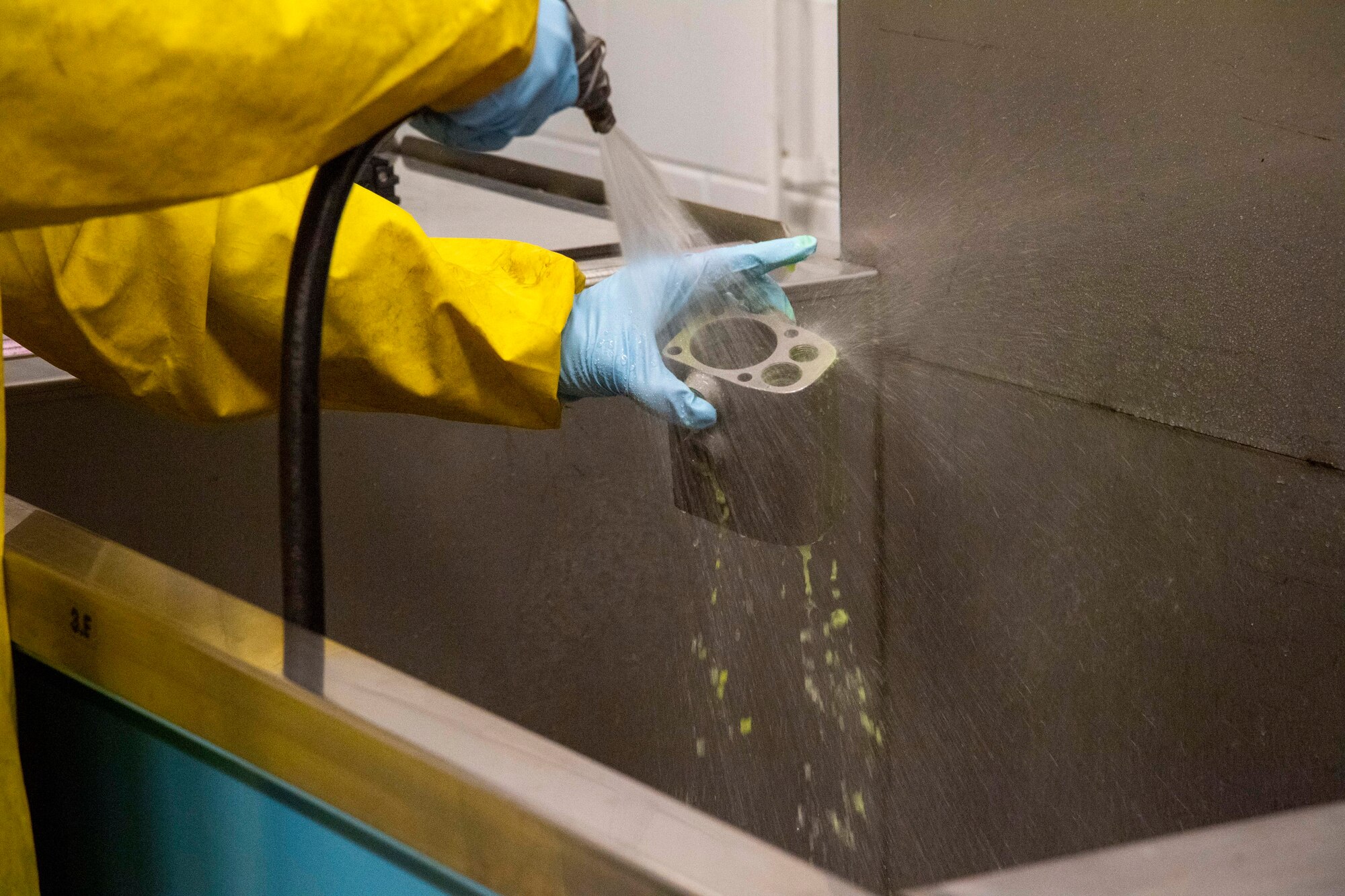 A maintainer with the 6th Maintenance Squadron nondestructive inspections unit rinses liquid penetrant off an aircraft part at MacDill Air Force Base, Florida, June 4, 2021.