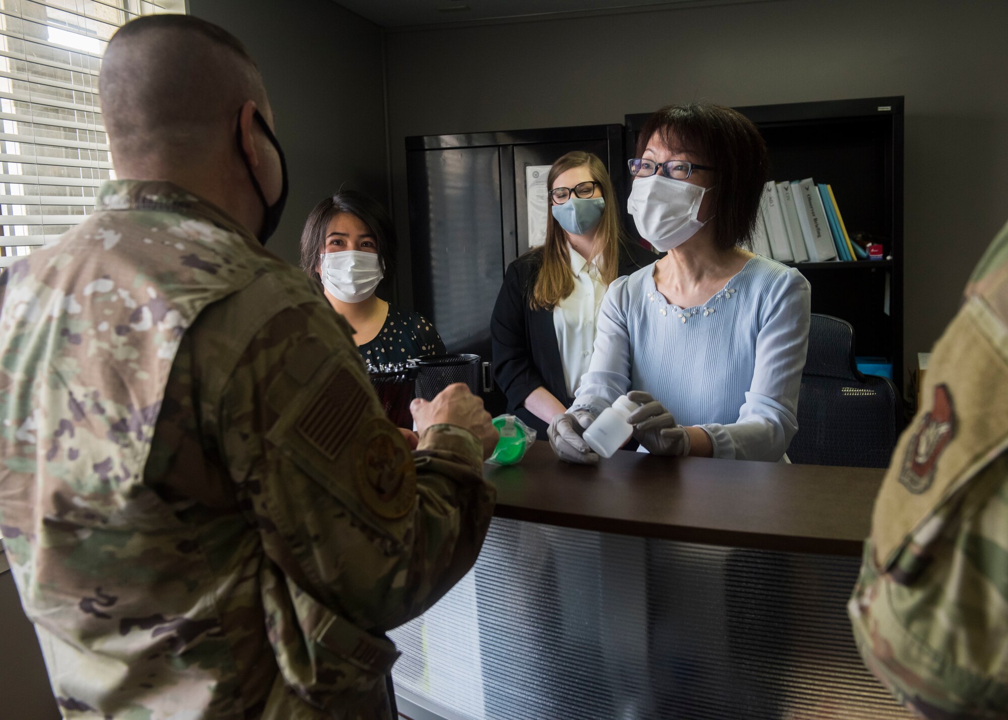 Members from the DDRP show empty bottles to men in U.S. Air Force uniforms.