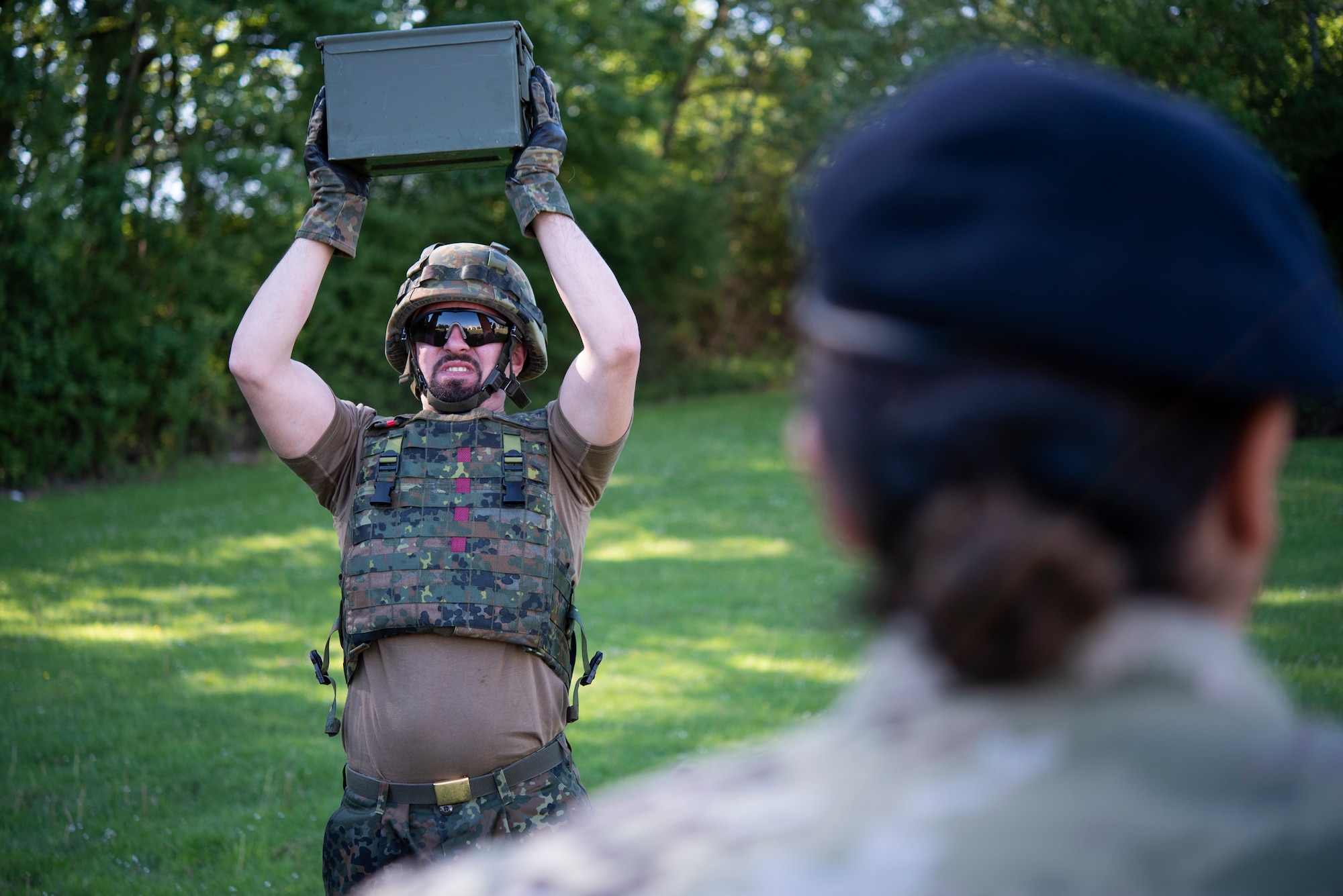 A member of the German Bundeswehr Military Police does overhead presses with a weighted ammo can as part of the Defender Challenge at Spangdahlem Air Base, Germany, June 2, 2021.