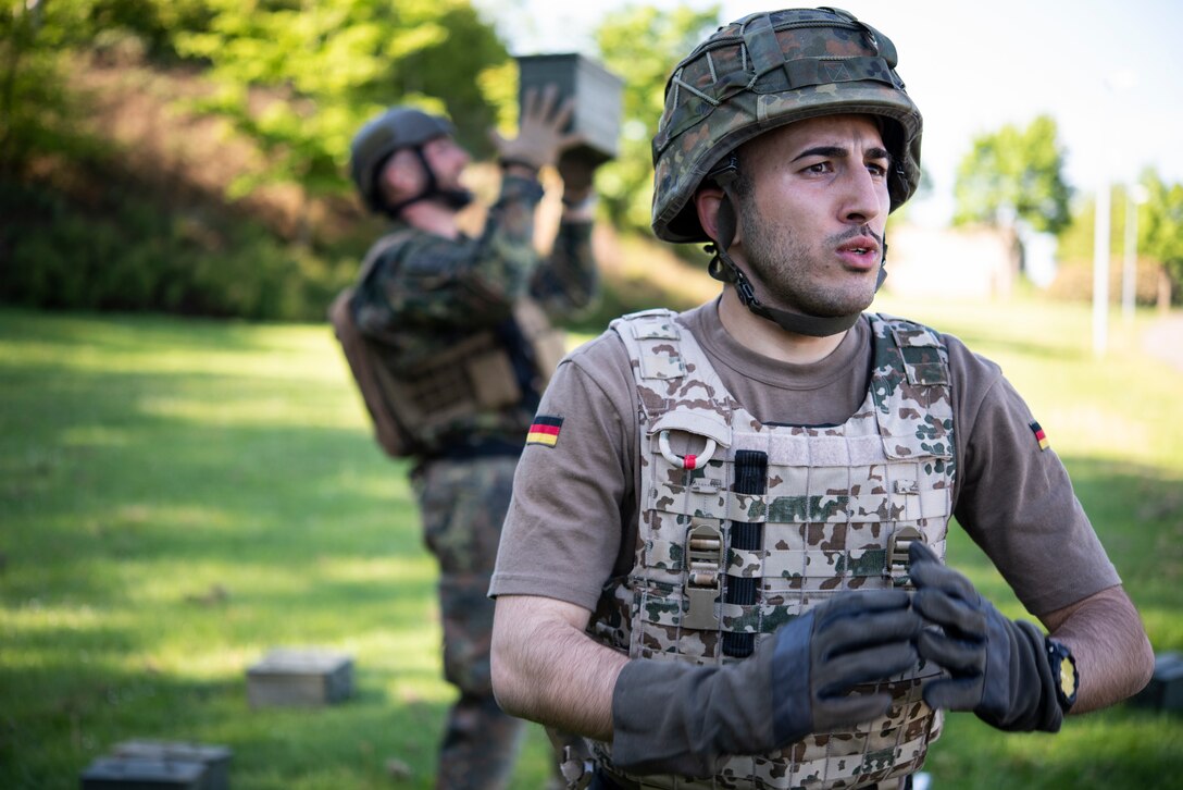 Members of the German Bundeswehr military police do squats and overhead presses with a weighted ammo can as part of the Defender Challenge at Spangdahlem Air Base, Germany, June 2, 2021.